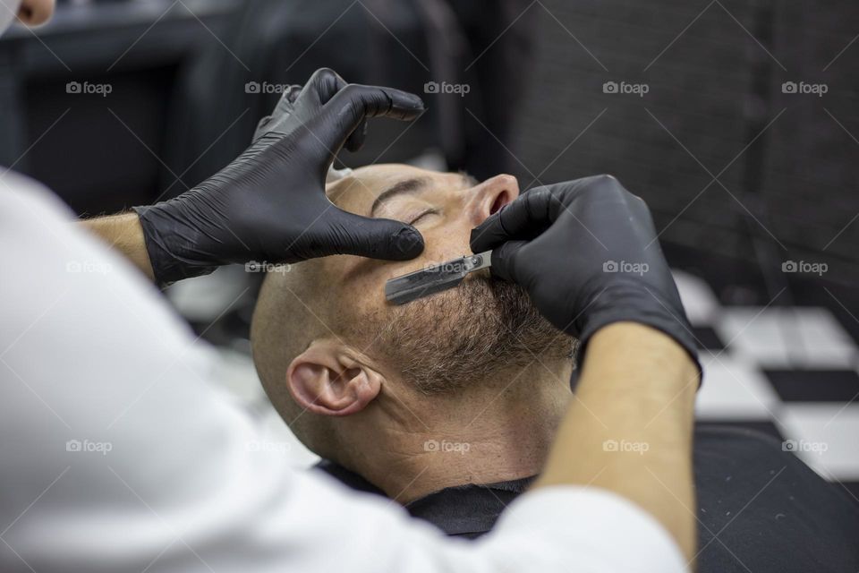 Barber shaving client with straight razor