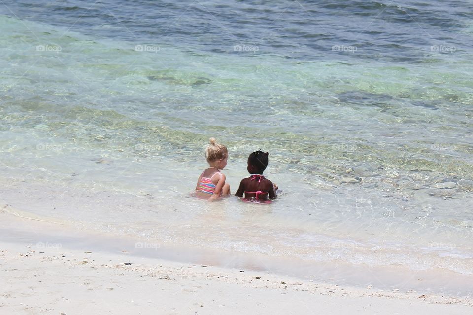 Two little girls playing in the ocean