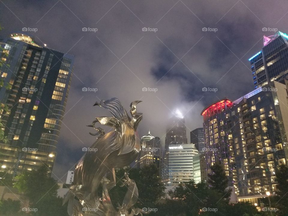 Dark cloudy & stormy Uptown Charlotte night skyline with high buildings lit.