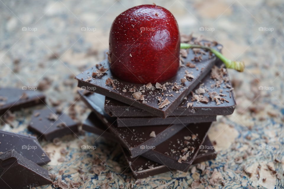 Pieces of dark chocolate stacked with a cherry on the top and sprinkled with grated chocolate ... delicious 