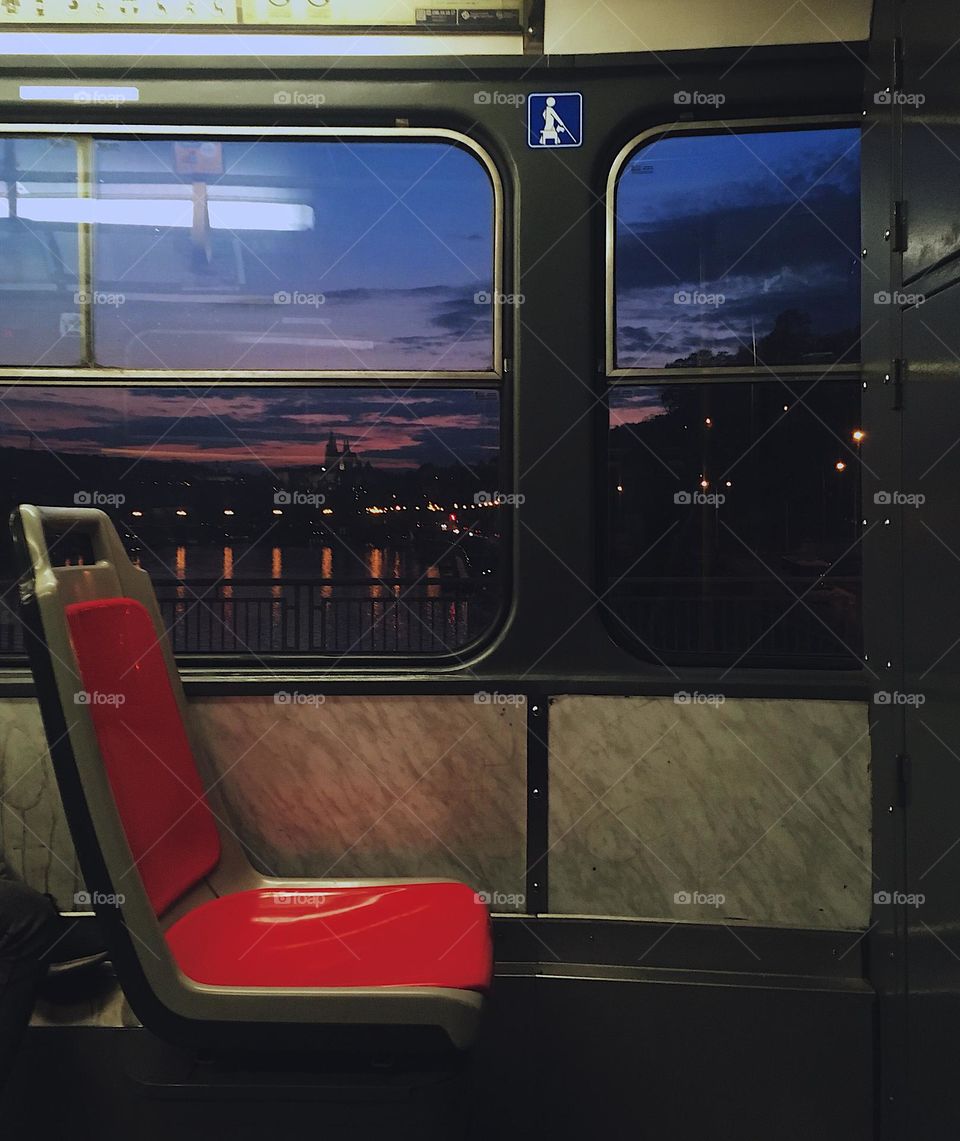 Empty? photographed sunset from the train window where there is an empty red seat