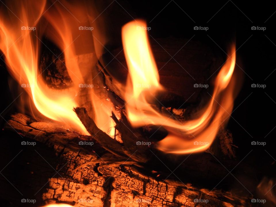 Beautiful wonders and colors in the flames with soft looking of a bonfire warming up the people in the late evening night of the fall season.