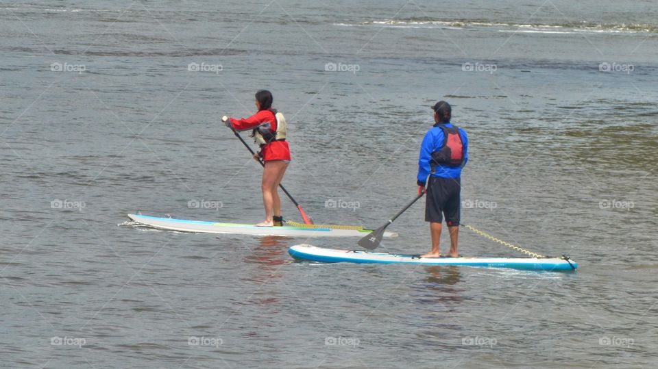 Couple paddle boarding on Hudson River in New York City