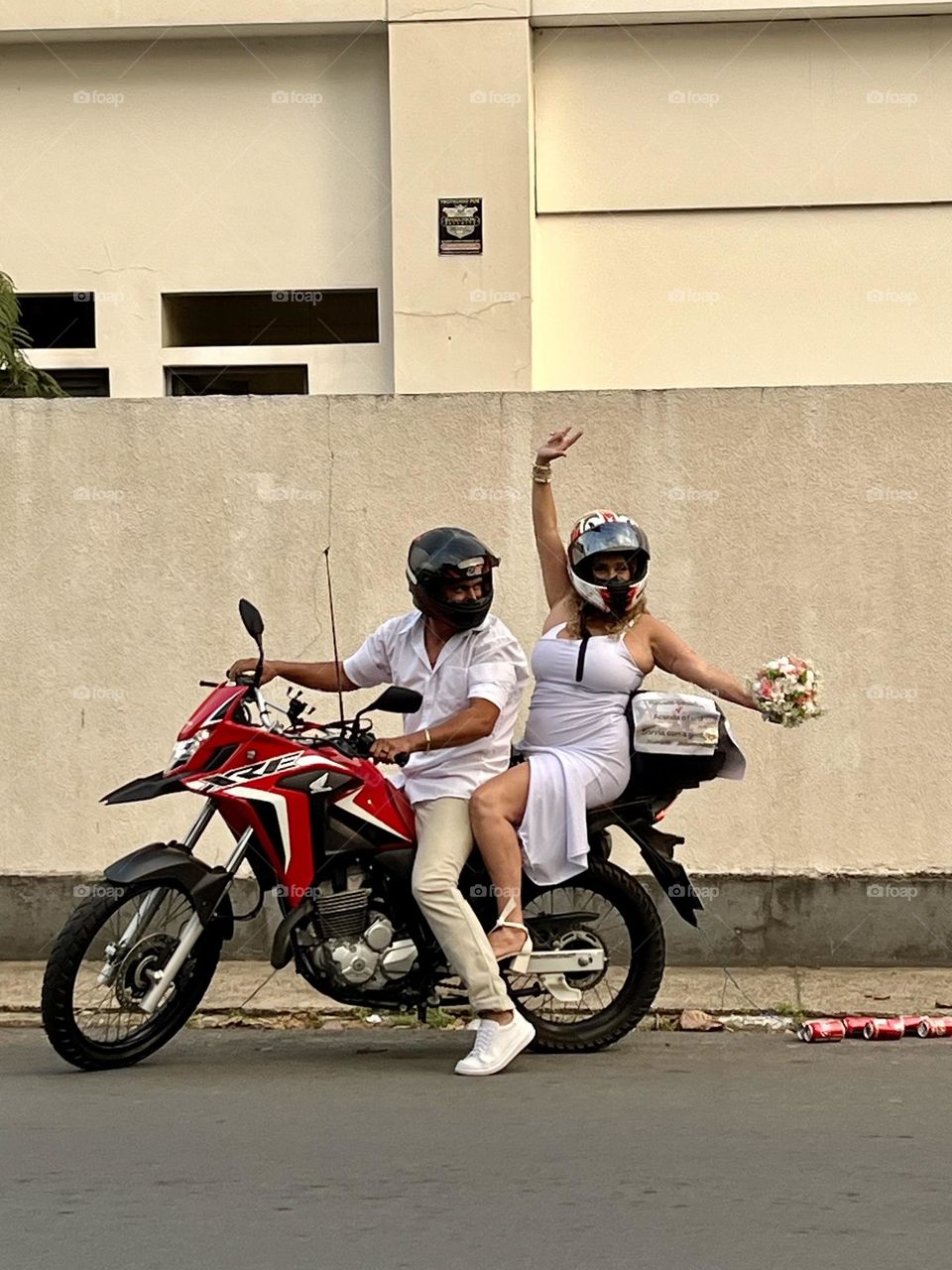 Modern bride and groom after the wedding on a red motorcycle 