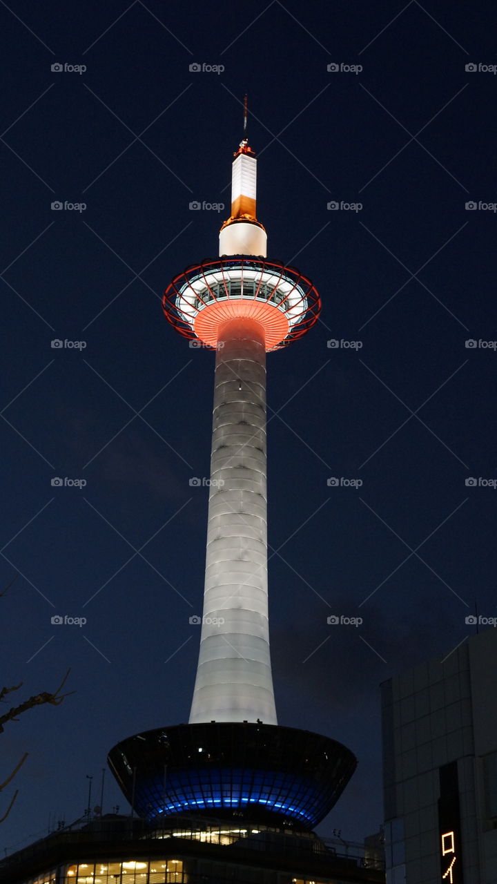 Kyoto Tower lit up at night, view from the Kyoto shinkansen station