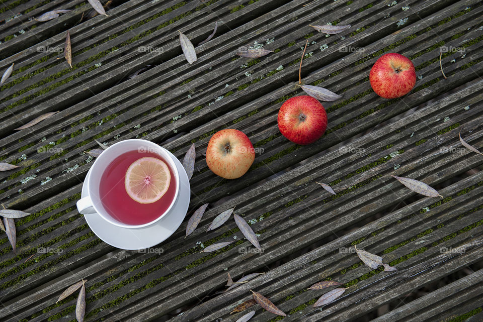 Autumn season holiday flat lay with tea cup and apples fruits on wooden background