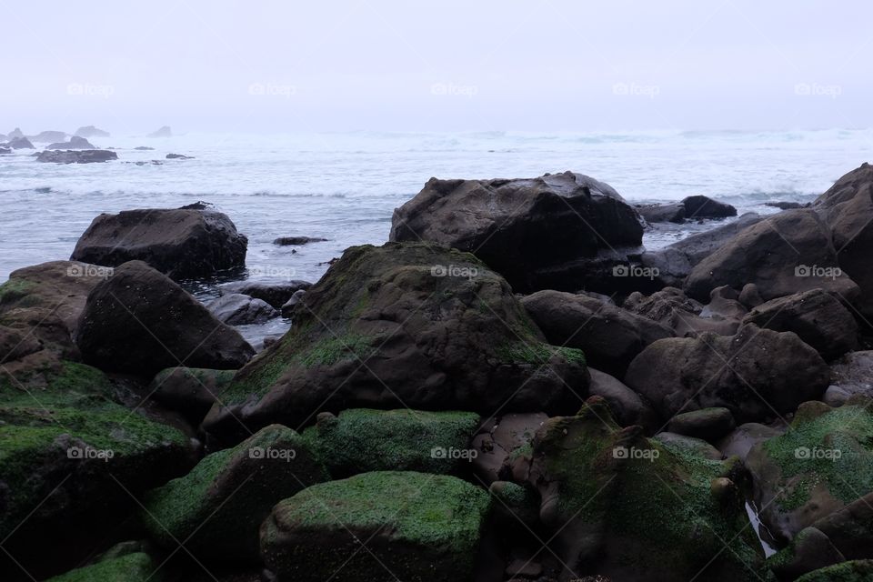 Water's rage. Ocean waves crashing on dark rocks.