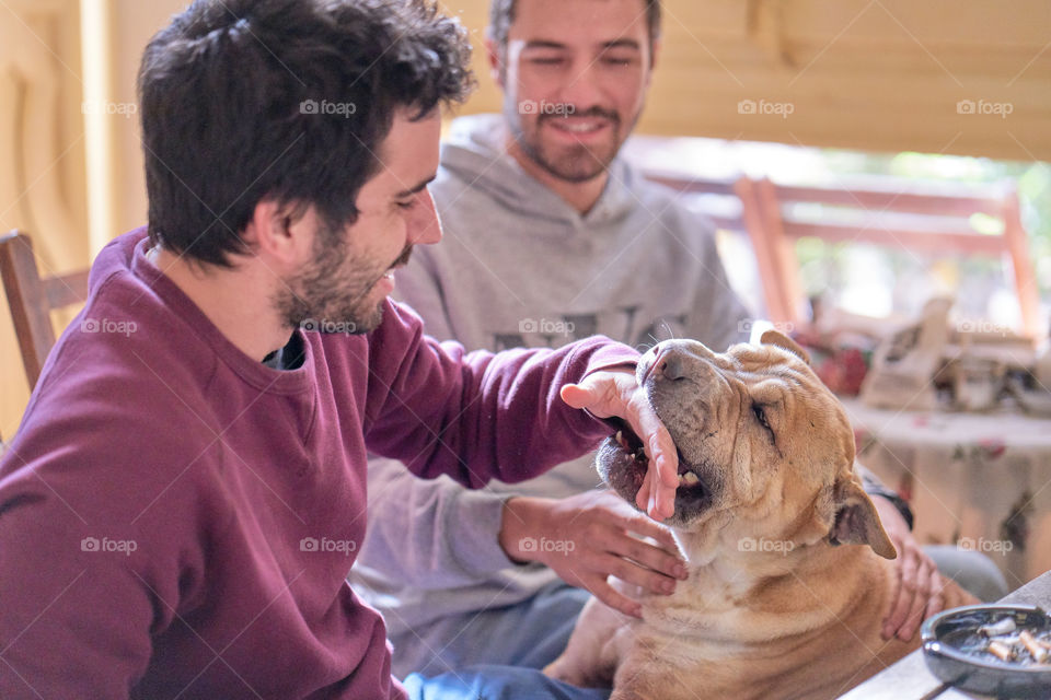 Two man playing with dog