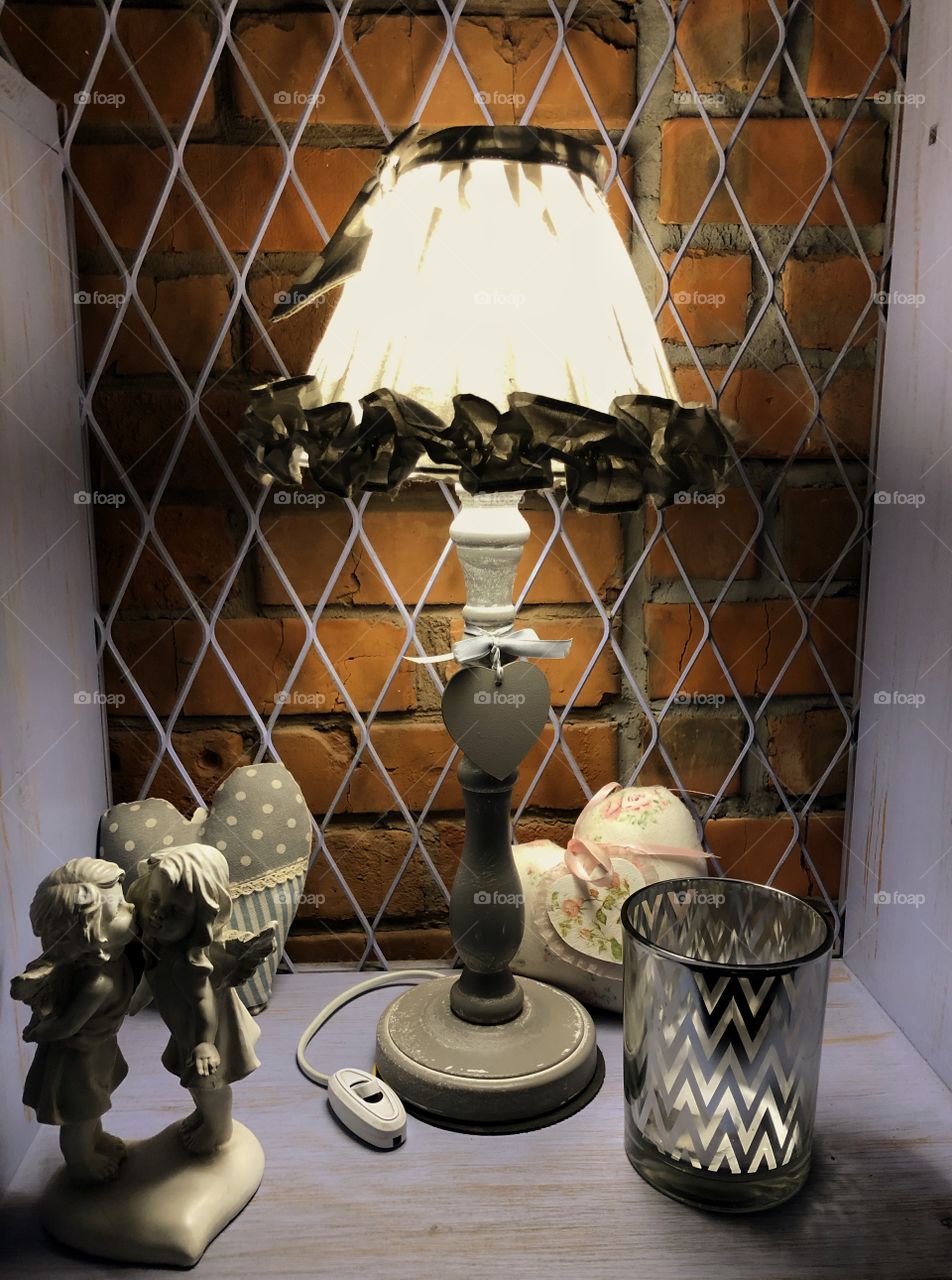 Interior design with lamp, candle, textile harts and kissing angels