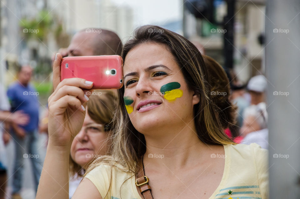 Mulher de cara pintada segura celular