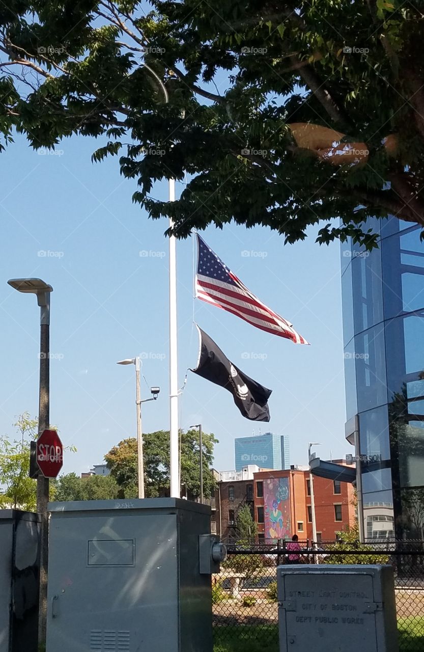 American Flag 🇺🇸 flying on flagpole showing the Boston skyline in background. Pic taken from street level.