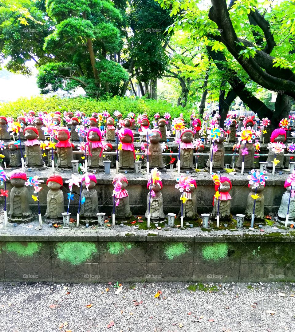 Little stone figures of children with hats, napkins and windmills. Tokyo, Japan.