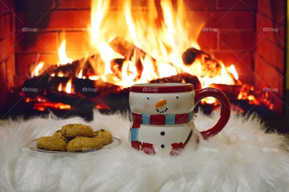 cappuccino with biscuits in front of the fireplace