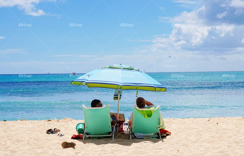 A couple relaxing on the beach in beach chairs