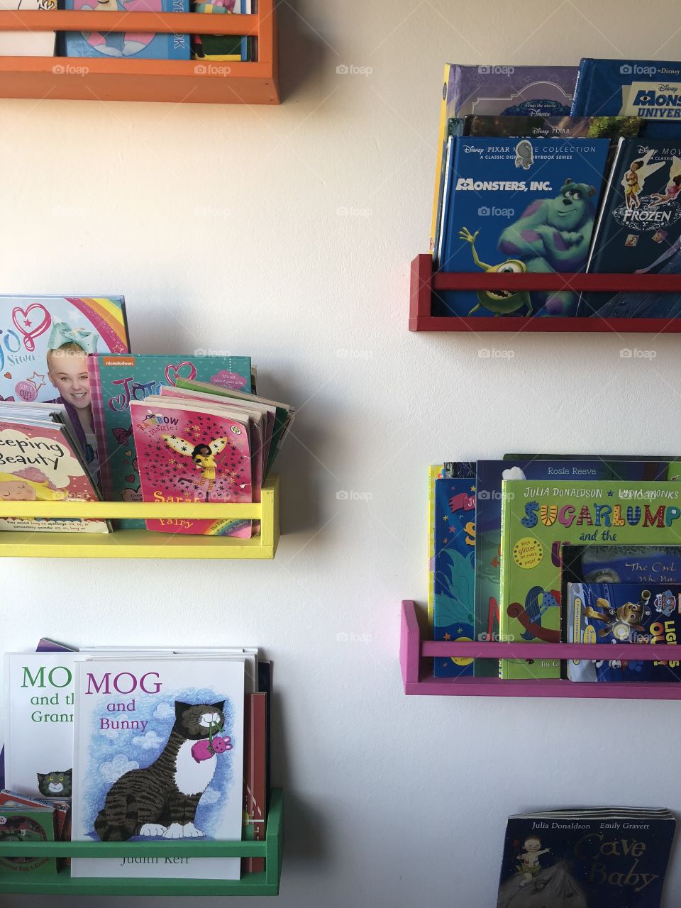 Children’s Books on shelves on white wall 