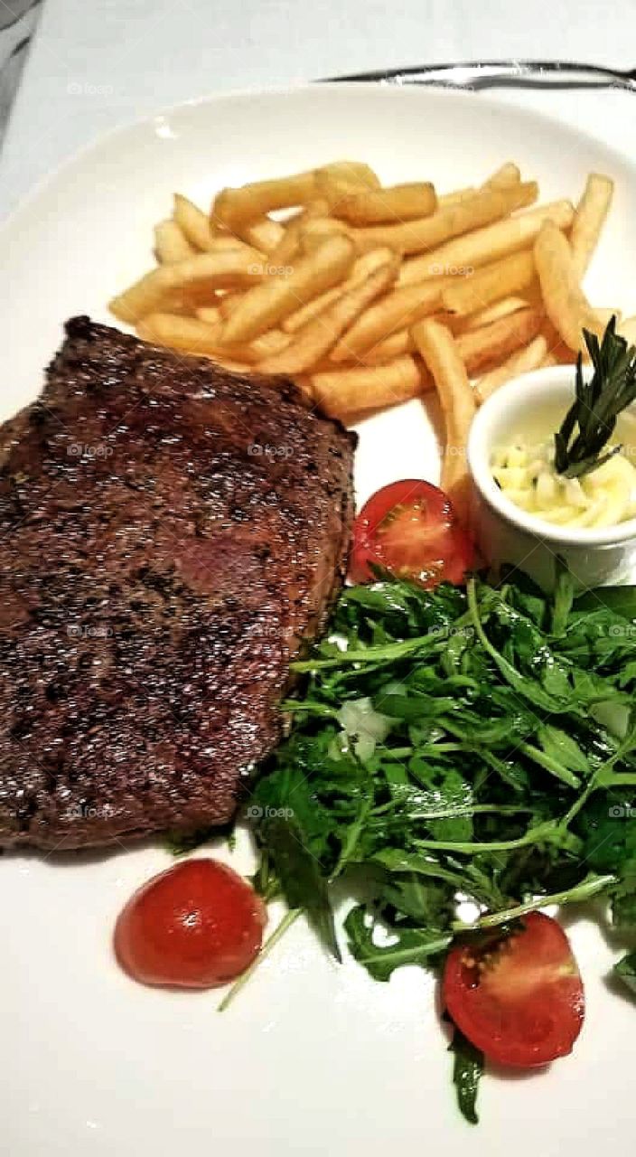 Steak, french fries and greens