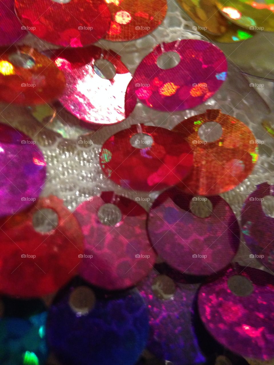 Sequins of a different color. Close up of sequins on a doll dress