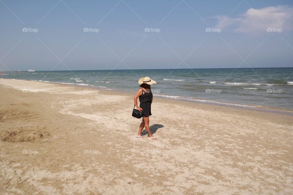 Woman walking against the sky on the beach