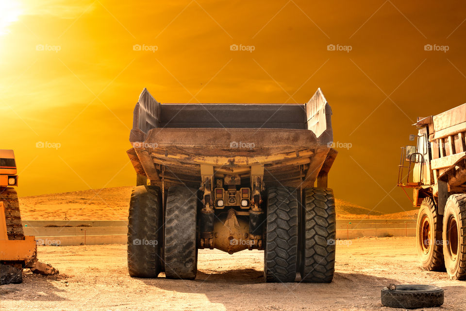 Heavy duty equipment, mining truck mildly blends with sunset light