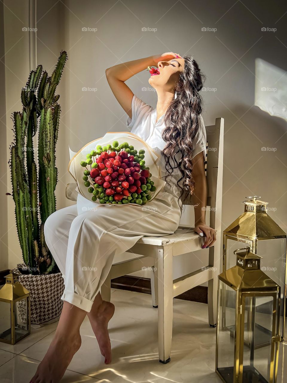 Curly haired girl with a bouquet of strawberries