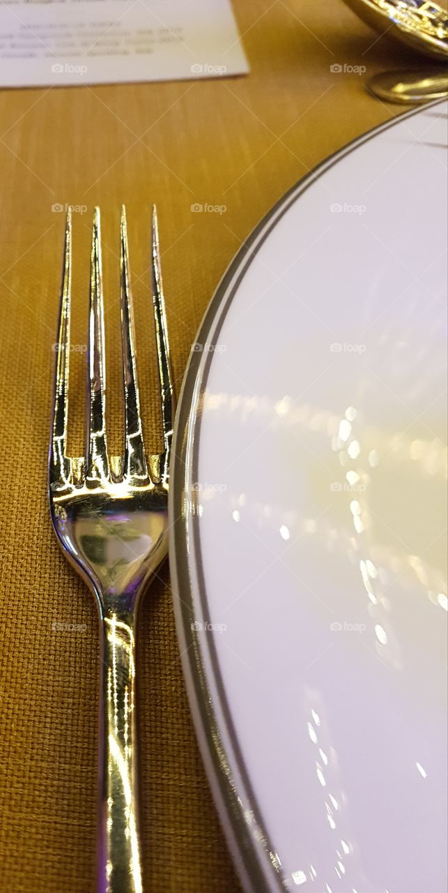close up shot of elegant cutelry and side plate set up on a table at a gastronomic restaurant