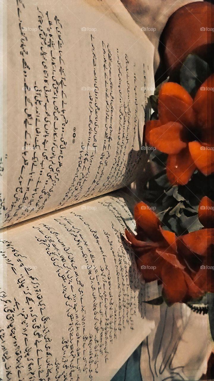 The open book on top of a flower in front of some text seems like a lovely combination of nature and knowledge. It's like a poetic scene captured in a single frame. ๐ธ๐