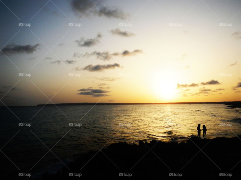 silhouette of two girl on gold sunset