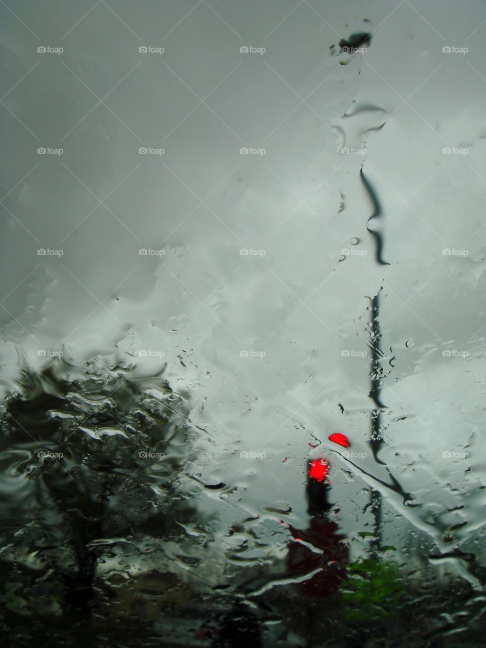 through a window, it is raining, the traffic light is red