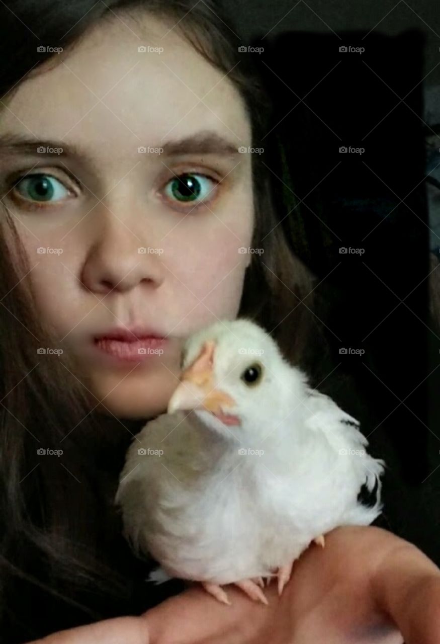A girl with far away eyes.  And a chicken.