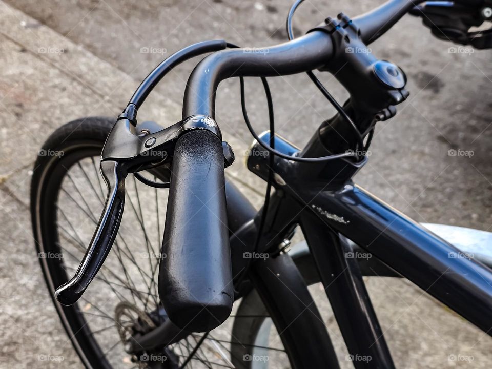 Closeup abstract of a black bicycle showcasing its handlebars on a city sidewalk in San Francisco California 