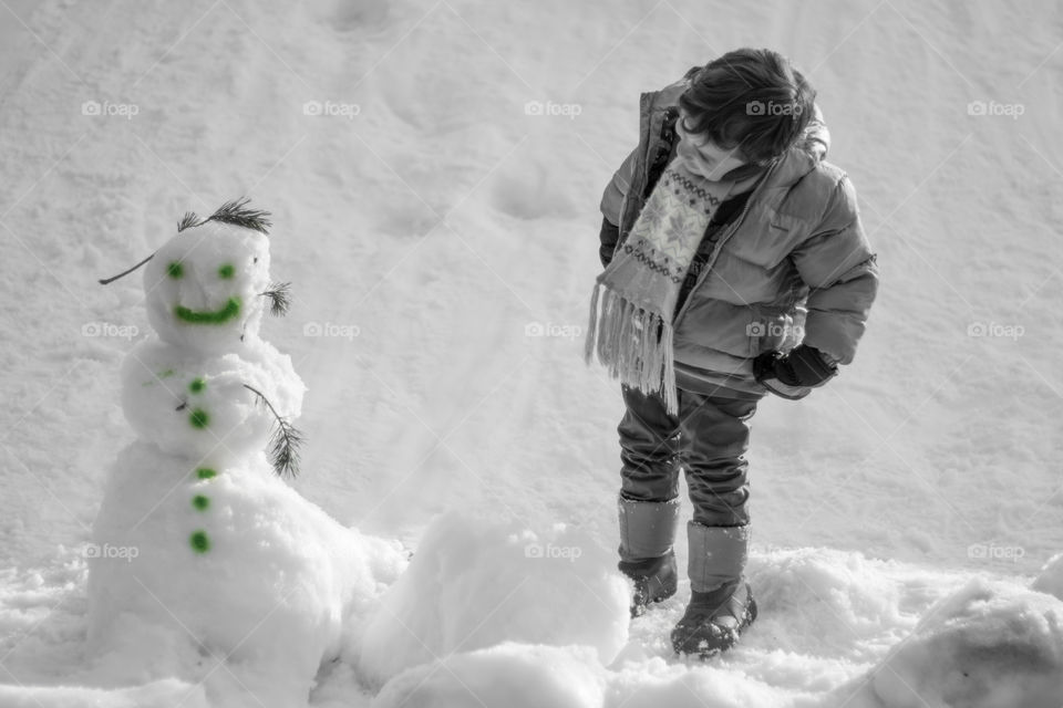 Child looking snowman