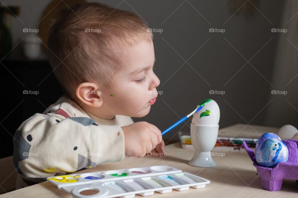 Toddler boy coloring easter eggs