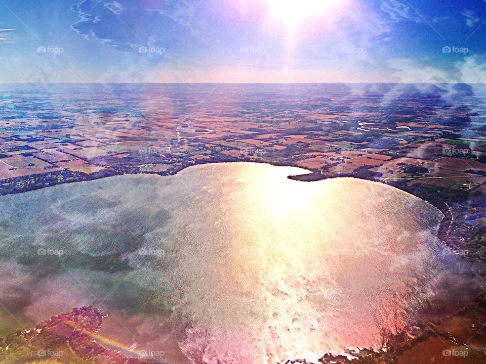 Aerial view. Aerial view of a lake reflecting the sun and clouds.