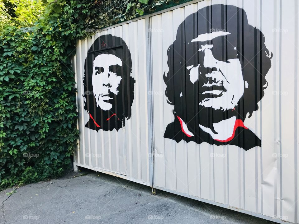 Gate with art Che Guevara and Kadafi