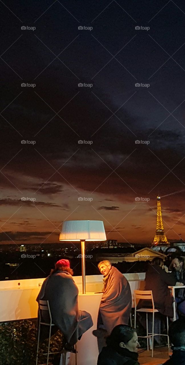 People sitting in restaurant with cityscape at night