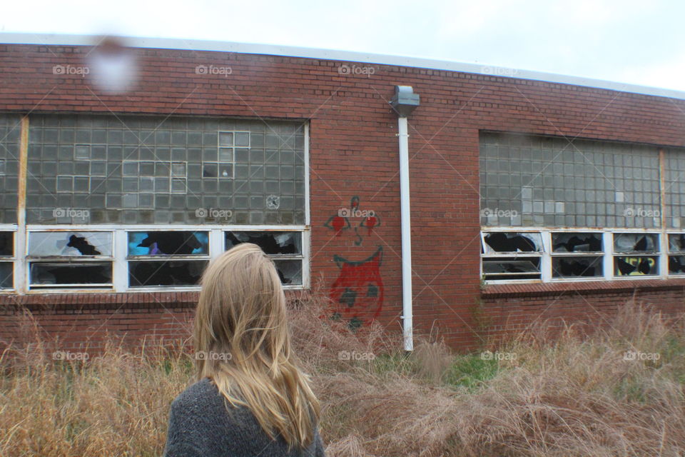 Blonde girl outside abandoned building
