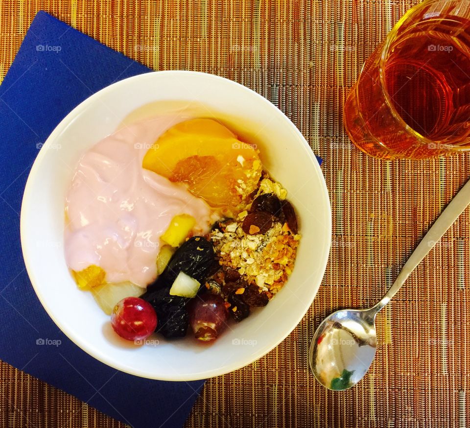 Bowl of muesli strawberry yoghurt dried prunes and fresh fruit for breakfast 