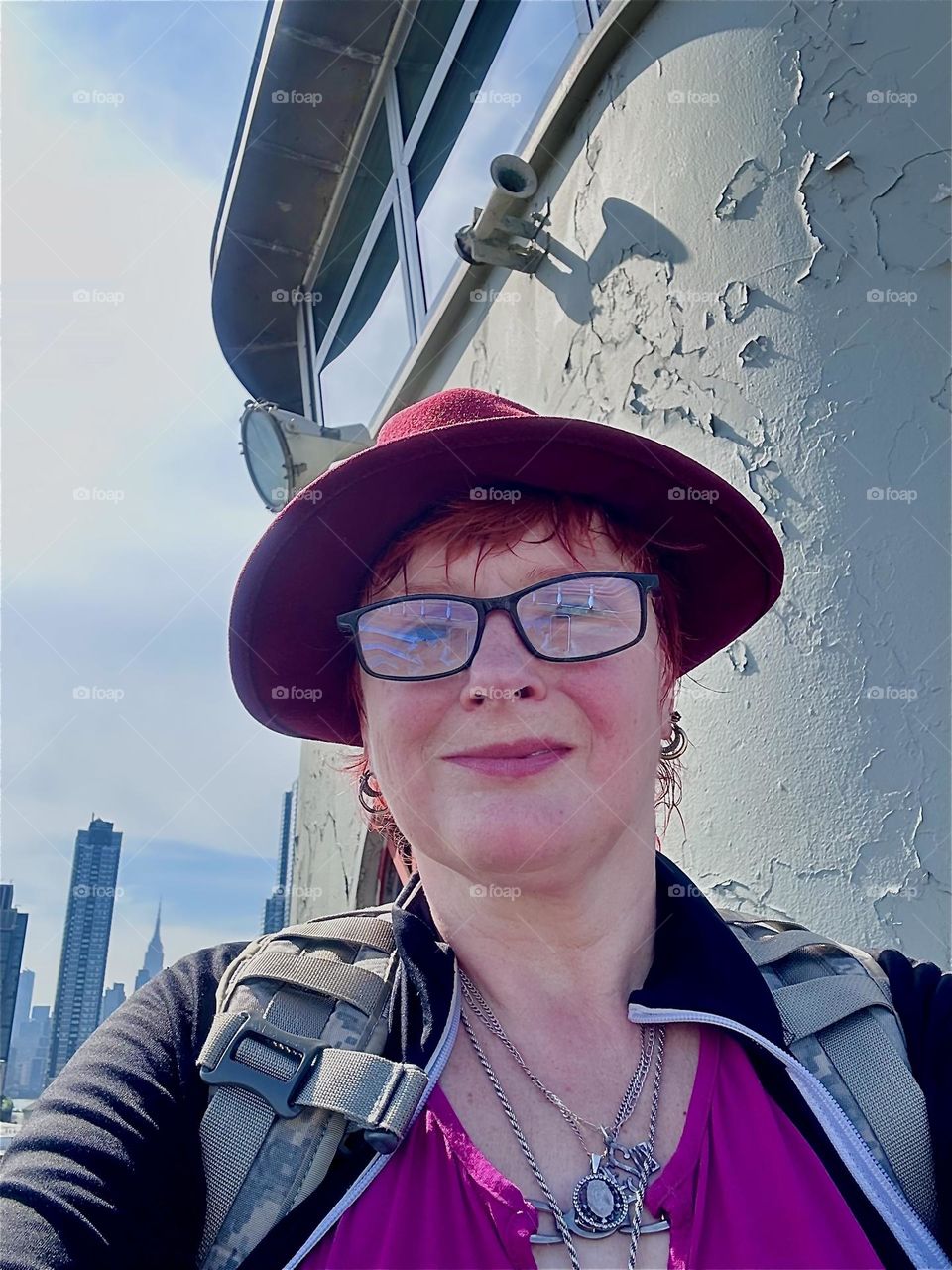 This is me, “Petra Schiller” a.k.a. “Maxine Firefox” standing by the center outpost of the “Pulaski Bridge” at “Newtown Creek” that connects “Greenpoint”, Bklyn to LIC, Queens on a sunny afternoon in May 2024. Hypnotic Productions