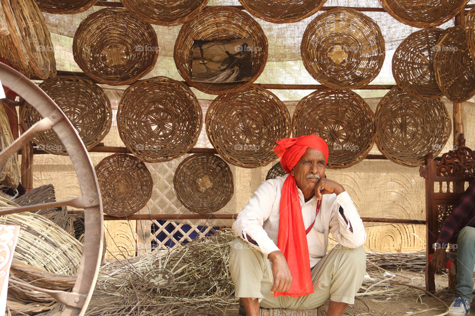 Seller selling handmade baskets at surajkund crafts mela in Faridabad, haryana, India