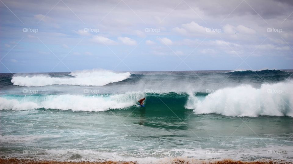 Surfing on the big wave at Sandy beach in Hawaii