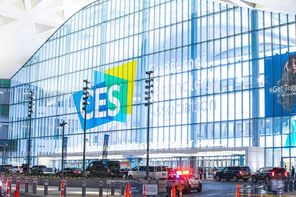 Las Vegas, NV, USA 1-6-2023: Exterior of Convention Center West Hall during CES2023. Logo of CES on glass wall. Light trails from car headlights of traffic passing by. Captured in long exposure.