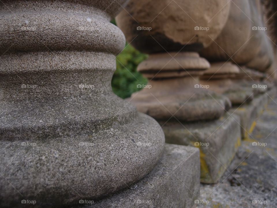 Decorative old stone support poles for railing on a bridge in England on a summer day. 
