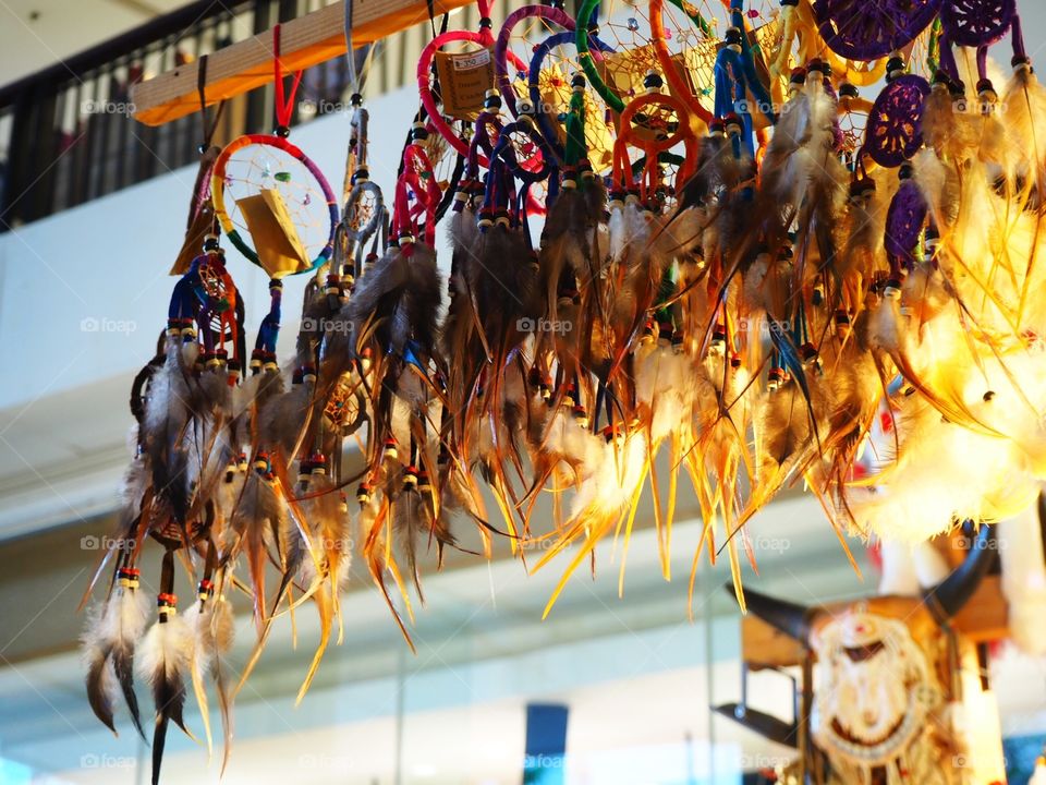 Colorful see mainly made of feathers hanging.