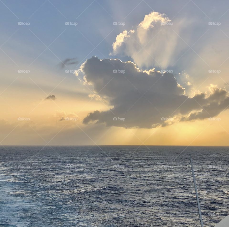 The sun behind a cloud over the ocean