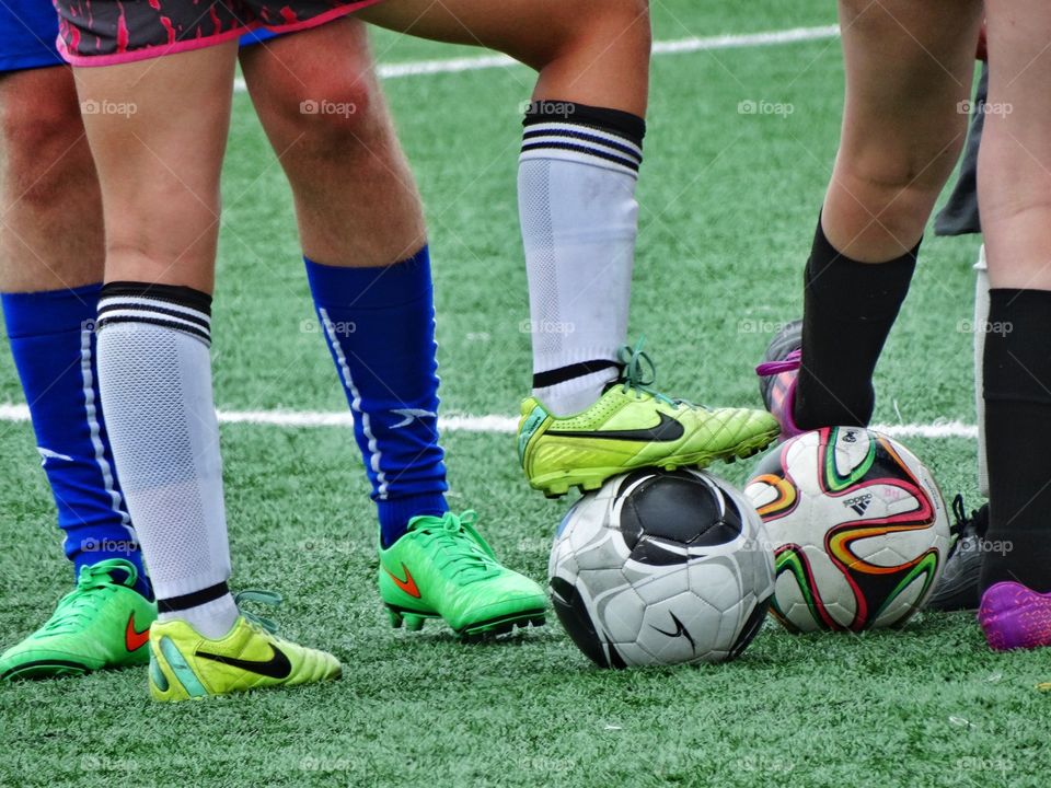 Feet On A Soccer Ball. Soccer Ball Surrounded By Feet
