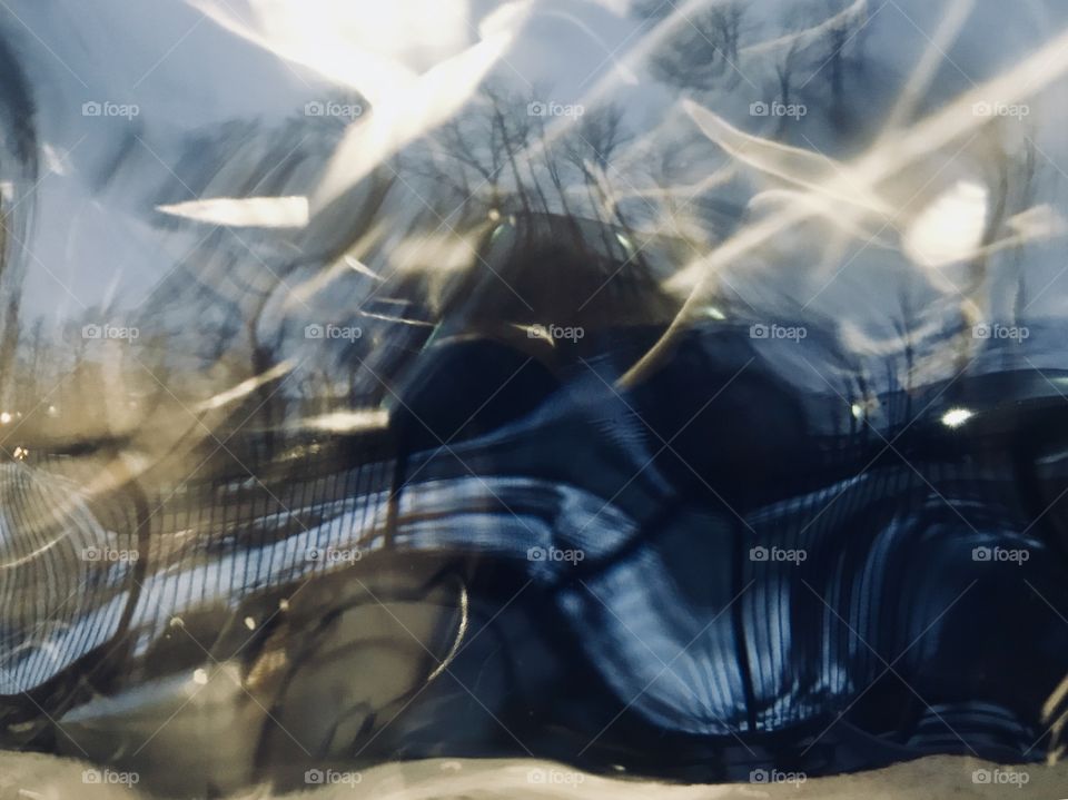 Peeking outside a distorted window to a sunrise scene outside. 