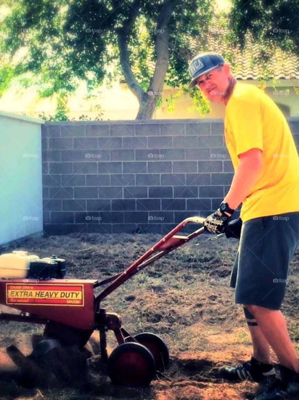 Yard work. Man and his rotter tiller
