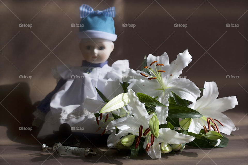 old doll and white lilies