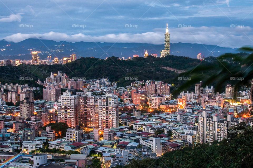 A blue sky sets in after dusk and the clouds settle into the mountains in Taipei. 