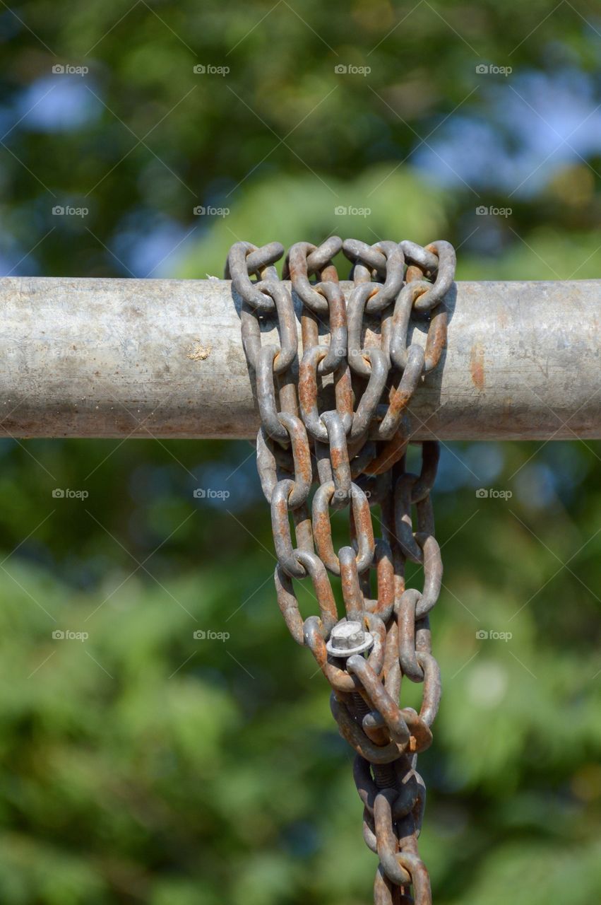 Old rusty chain on iron pole